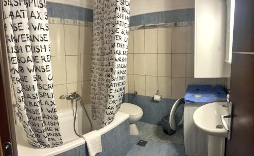 y baño con aseo y cortina de ducha. en Bluebay Lux Apartment of Halkidiki, en Sozopoli