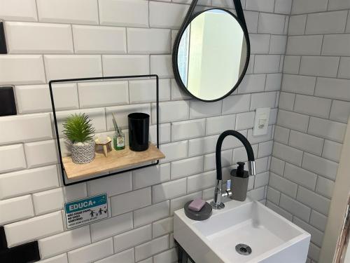 a bathroom with a sink and a mirror at Hostel Quintal de Casa in Foz do Iguaçu
