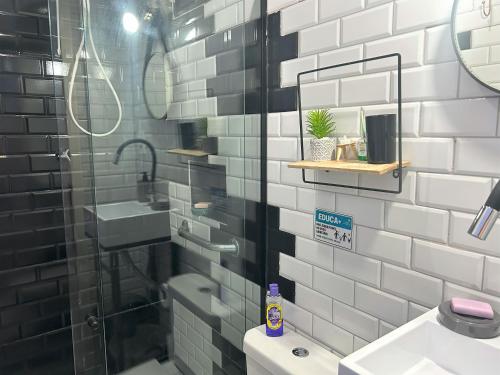 a bathroom with a shower and a sink and a mirror at Hostel Quintal de Casa in Foz do Iguaçu