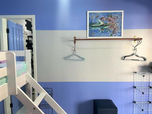 a blue room with a staircase and a painting on the wall at Hostel Quintal de Casa in Foz do Iguaçu