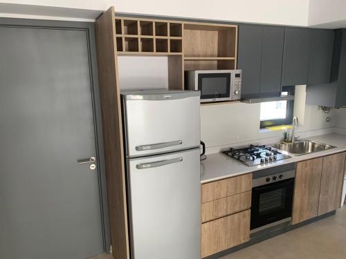 Una cocina con un refrigerador blanco y un microondas. en Dpto Bastion del Este 103, en Tandil