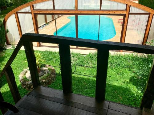 uma vista para uma piscina através de uma janela em Gîte Maison Made in Normandie em Bois-Normand-près-Lyre