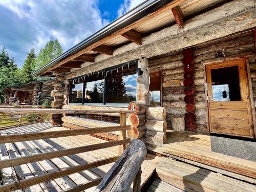 een blokhut met een houten veranda en een deur bij Villa Saarua by the Slopes Ski in, Family & Bike Park, hike trails, National Park, WiFi - Lapland Villas in Ruka