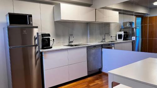 a kitchen with white cabinets and a stainless steel refrigerator at Westfjords - Rooms in Bolungarvík
