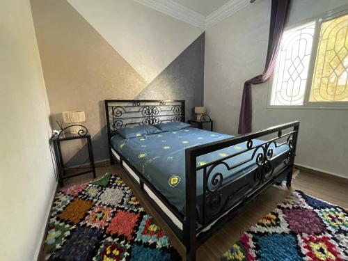 a bedroom with a black bed and a rug at Douja Ferme in Ouirgane