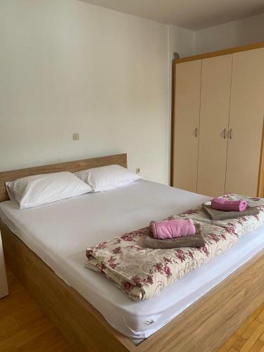 een wit bed met twee kussens erop bij Urban Inn Apartments Ohrid in Ohrid