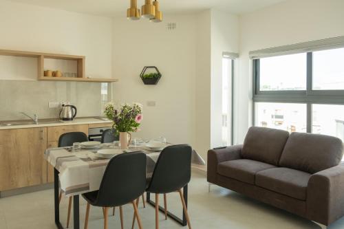 ein Wohnzimmer mit einem Tisch und einem Sofa in der Unterkunft Side-seaview apartment near beach and close to St. Julians in Baħar iċ-Ċagħaq