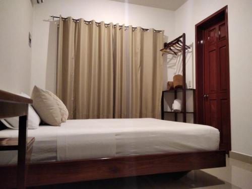 1 dormitorio con cama y cortina en Apartamento en Bacalar