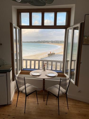 a dining room with a table and a view of the beach at Le Petit Saint Cast - Cocon vue Mer in Saint-Cast-le-Guildo