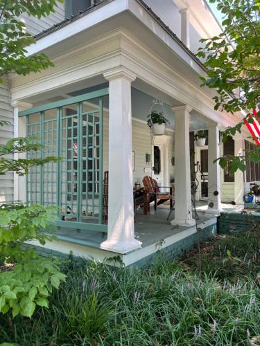 a screened in porch on a white house at Magnolia House & Gardens B&B in Clover