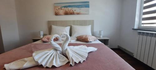- une chambre avec un lit avec un cygne fait de serviettes dans l'établissement Apartament Jenny, à Mangalia