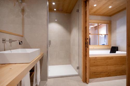 uma casa de banho com uma banheira, um lavatório e um chuveiro em Al Capriolo em Vodo Cadore