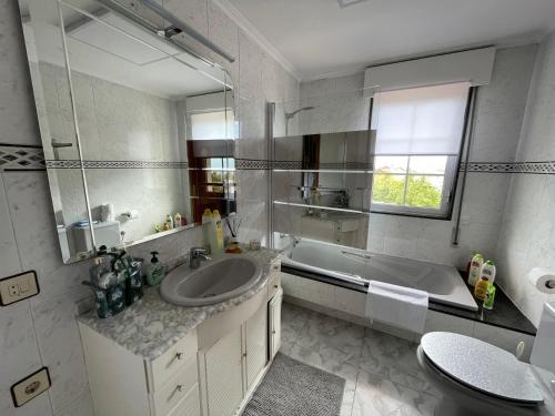 a bathroom with a sink and a tub and a mirror at Ashram de La Peral in Illas