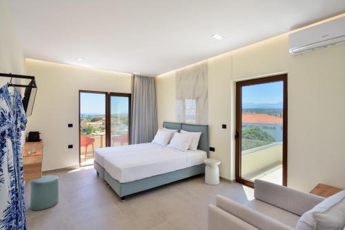 a bedroom with a white bed and a balcony at Panthea Luxury Living in Kolymvari
