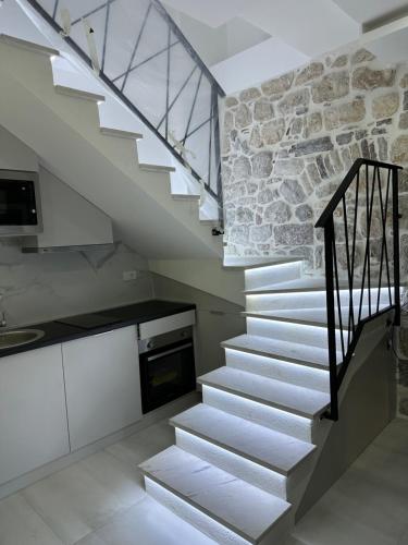 eine Treppe in einem Haus mit einer Steinmauer in der Unterkunft Casa di Lukovic in Tivat