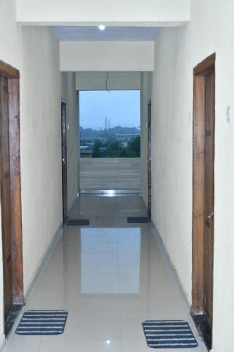 un couloir vide avec des portes et une vue sur un bâtiment dans l'établissement Hotel jay malhar and lodging, à Igatpuri