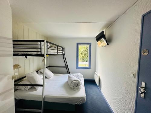 a small room with two bunk beds and a window at Hôtel Gex in Gex