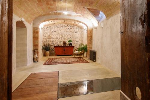 a large room with a stone wall and a table at Casa bascara in Báscara