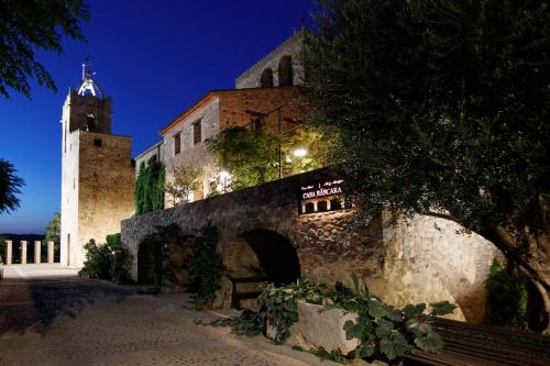 a building with a clock tower and a building with a bench at Casa bascara in Báscara