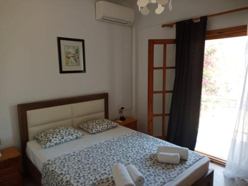 a bedroom with a bed and a window at St Paul and Peter's House in Asprovalta