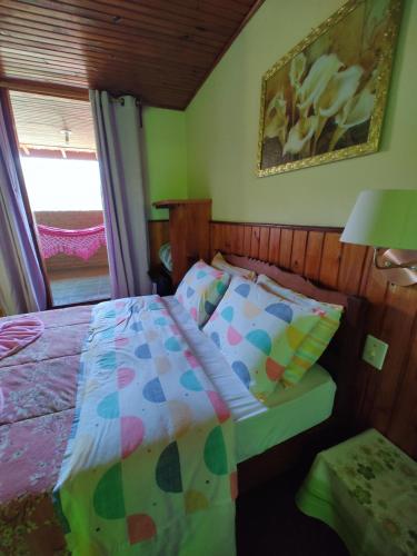 a small bedroom with a bed and a window at Pousada Solar das Flores Maringá RJ Visconde de Mauá in Visconde De Maua