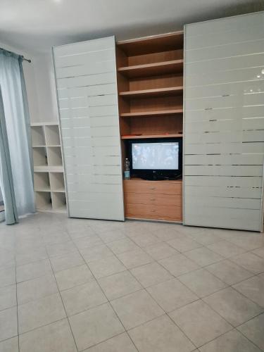 una habitación con TV y una habitación con estanterías en GENOVA LOFT 4.3, en Génova