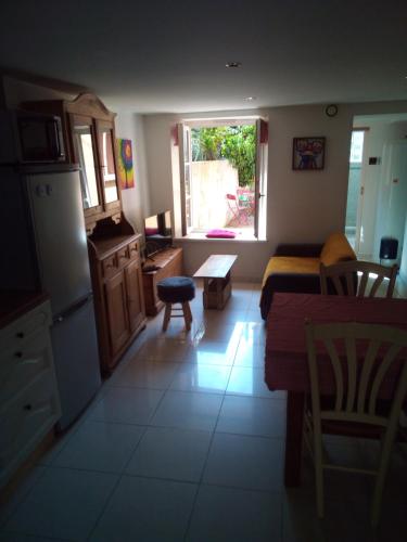 - une cuisine avec un réfrigérateur et une table dans la chambre dans l'établissement L'OASIS maisonnette centre ville 3 chambres terrasse espace vert privé parc sainte croix center parc 20 minutes, à Sarrebourg