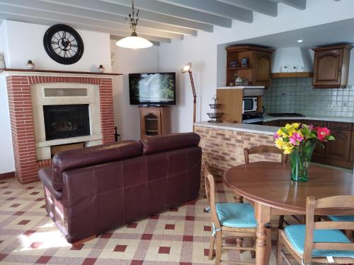 a living room with a couch and a table at Gîte charmant à 35 minutes plages du débarquement 