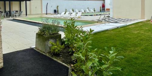 a courtyard with a pool with chairs and plants at Thermal Family Resort in Baile Felix