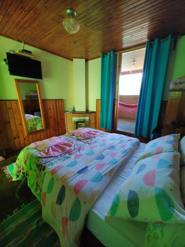 a bedroom with a bed and a mirror and blue curtains at Pousada Solar das Flores Maringá RJ Visconde de Mauá in Visconde De Maua