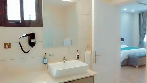 a bathroom with a sink and a phone on the wall at 24 Roma in Lusaka