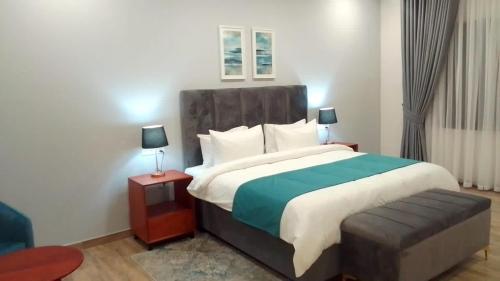 a bedroom with a large bed and a chair at 24 Roma in Lusaka