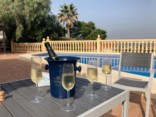 a table with wine glasses and a bottle of wine at Villa Bello Horizonte regio Denia - Javea in Pedreguer