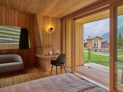 1 dormitorio con cama, escritorio y ventana en Hotel Glocke, en Reckingen - Gluringen