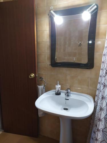 a bathroom with a white sink and a mirror at Apartamento con vistas al mar y buena ubicación in Benicàssim