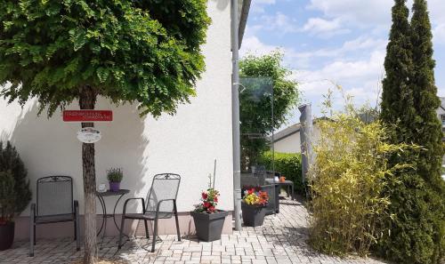 a patio with chairs and a table and a tree at Ferienwohnung Sommerwind in Willingen