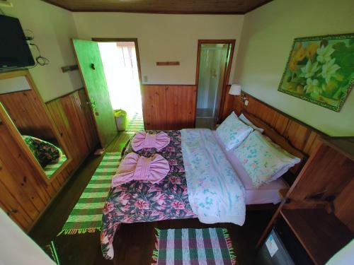 a small bedroom with a bed and a television at Pousada Solar das Flores Maringá RJ Visconde de Mauá in Visconde De Maua