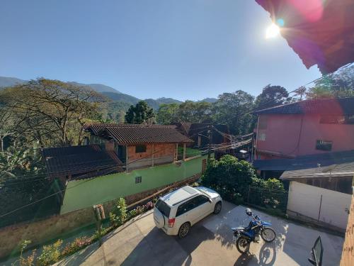 a man on a bike and a car parked in a street at Pousada Solar das Flores Maringá RJ Visconde de Mauá in Visconde De Maua