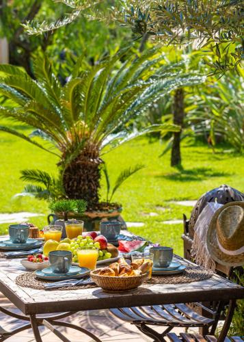 een picknicktafel met fruit en sap erop bij Hotel La Garbine in Saint-Tropez