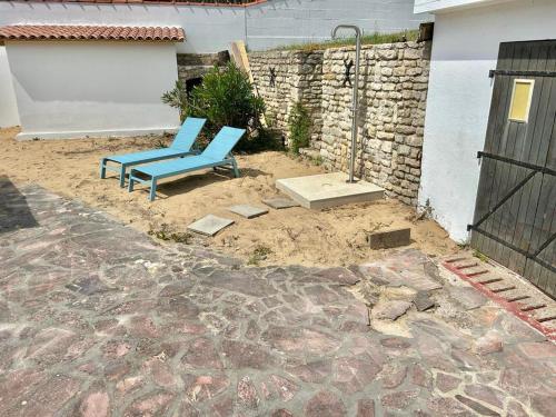 two blue chairs sitting in the dirt near a building at Maison 100m plage- La tranche sur mer - la terrière in La Tranche-sur-Mer