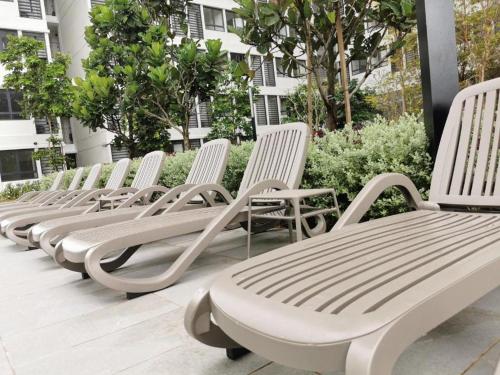 a row of white chairs sitting on a patio at Horizon Suites Sepang - Studio Unit in Kampong Melot