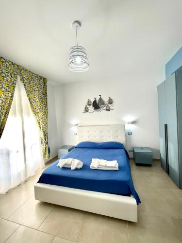 um quarto com uma cama azul e 2 toalhas em B&B Marconi em Ricadi