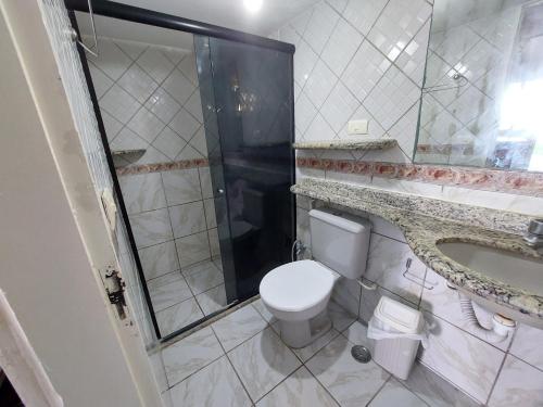 a bathroom with a toilet and a shower and a sink at Chalés Village Gales in Maragogi