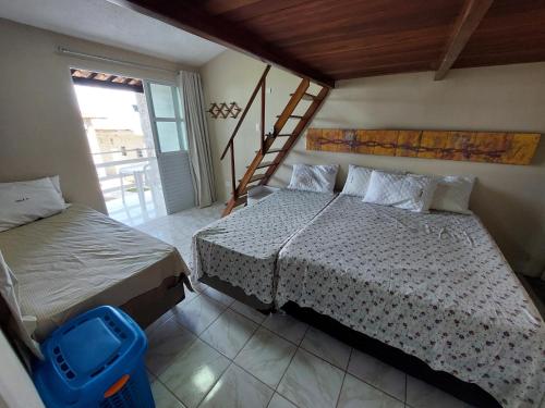 a bedroom with two beds and a staircase in it at Chalés Village Gales in Maragogi