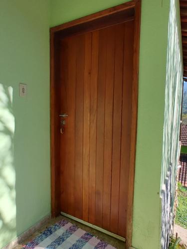a wooden door in the corner of a room at Pousada Solar das Flores Maringá RJ Visconde de Mauá in Visconde De Maua