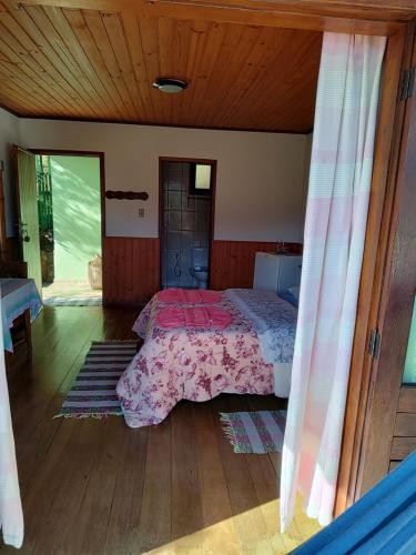 a bedroom with a bed with a pink bedspread at Pousada Solar das Flores Maringá RJ Visconde de Mauá in Visconde De Maua