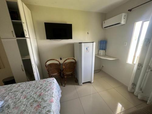 een kleine kamer met een koelkast en 2 stoelen bij Carneiros Tamandare Apart Hotel Marinas in Tamandaré