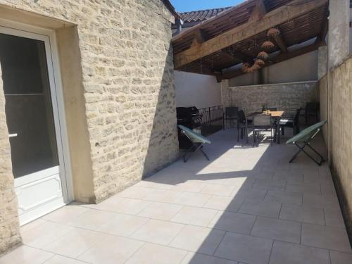 d'une terrasse avec des chaises et des tables dans un bâtiment en briques. dans l'établissement Maison 6-8 pers au cœur du village, à Malaucène