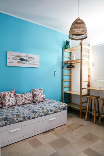 a bedroom with a bed and a blue wall at Casa VersoMare Rooftop in Gagliano del Capo