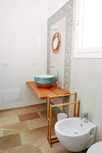 a bathroom with a sink and a bowl on a table at Casa VersoMare Rooftop in Gagliano del Capo